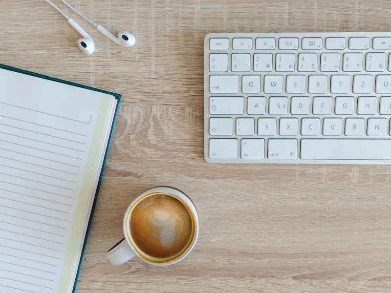 Notitieblok met dagplanning op een bureau naast een kop koffie